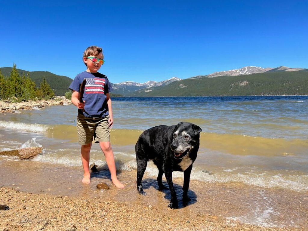 kid and dog by lake